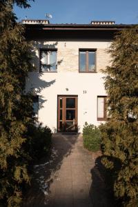 biały budynek z drzwiami i przejściem w obiekcie Home studio z ogródkiem i altaną w Krakowie