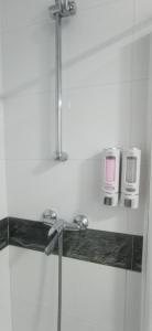 La salle de bains est pourvue d'une douche et de 2 fours micro-ondes sur une étagère. dans l'établissement Geranio Chipionahome, à Chipiona