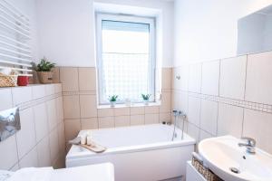 biała łazienka z wanną i umywalką w obiekcie Home studio z ogródkiem i altaną w Krakowie