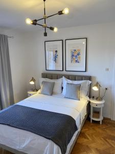 a bedroom with a large white bed with two lamps at Apartments Skako in Makarska