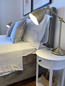 una lámpara en una mesa junto a una cama con almohadas en Apartments Skako, en Makarska