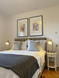 a bedroom with a large bed with two pictures on the wall at Apartments Skako in Makarska