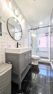 a bathroom with a sink and a toilet and a mirror at Modern/Luxury 2 bdrm- KING Bed- University City in Philadelphia