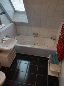 a bathroom with a bath tub and a sink at Ferienwohnung Welcome in Telgte