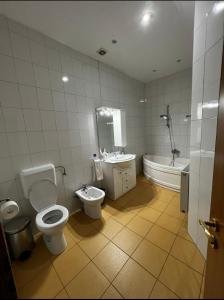 a bathroom with two toilets and a tub and a sink at Apartament central Timisoara in Timişoara