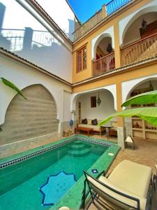 a swimming pool in a house with chairs and a table at Riad Tafilag in Taroudant