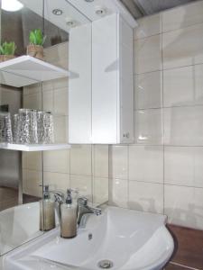 La salle de bains est pourvue d'un lavabo et de placards blancs. dans l'établissement Guest House Končar, aux lacs de Plitvice