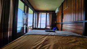 1 dormitorio con 1 cama y vistas al océano en Terimakasih homestay, en Pulau Mansuar