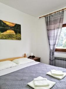 1 dormitorio con 1 cama con toallas en Guest House Končar, en Lagos de Plitvice