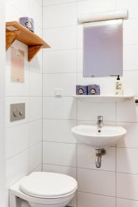 a white bathroom with a toilet and a sink at Cocomama in Amsterdam