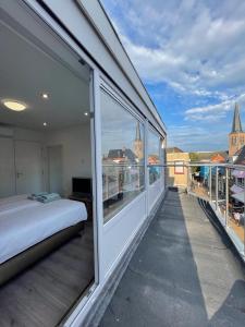 a bedroom with a bed on a balcony at Pension Marco in Zandvoort