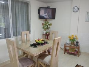 una sala da pranzo con tavolo, sedie e TV di Araucarias Inn 2 a Santa Rosa de Cabal