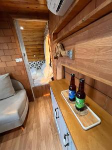 two bottles of beer on a table in a tiny house at קסיופאה חוויה במדבר in Yeroẖam