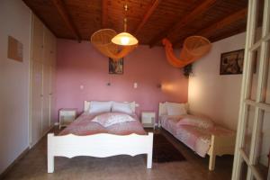 een slaapkamer met een wit bed en een roze muur bij Niky's cottage in Paleokastritsa