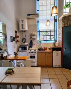 una cocina con electrodomésticos blancos, mesa y sillas en Calle del Aire en Buenos Aires