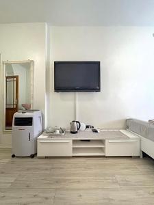 sala de estar con TV de pantalla plana en la pared en Pension Marco, en Zandvoort