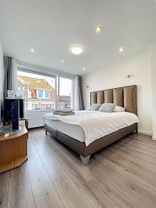 a bedroom with a large bed and a large window at Pension Marco in Zandvoort