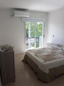 1 dormitorio con cama y ventana grande en Departamento en Costanera en Gualeguaychú