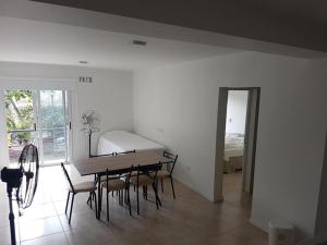 comedor con mesa, sillas y cama en Departamento en Costanera en Gualeguaychú