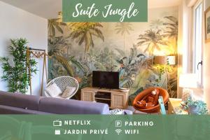 a living room with a blue couch and palm wallpaper at SUITE JUNGLE - JARDIN, NETFLIX et PARKING - Le Manoir aux Pommes in Orbec-en-Auge