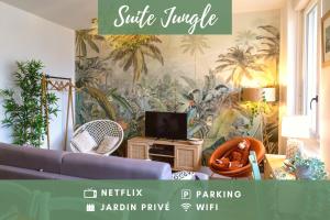 uma sala de estar com um sofá azul e papel de parede de palma em SUITE JUNGLE - JARDIN, NETFLIX et PARKING - Le Manoir aux Pommes em Orbec-en-Auge