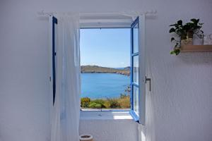 een open raam met uitzicht op de oceaan bij Hidden Serenity in Mykonos-stad