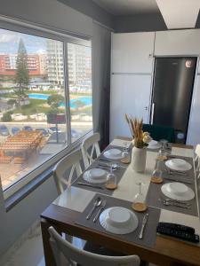 a dining room with a table and a large window at SEA FRONT in Armação de Pêra