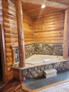 a bathroom with a tub in a log cabin at Best Western White House Inn in Bangor