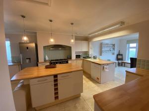uma grande cozinha com armários brancos e uma bancada em Meadow View em Haverfordwest