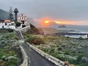een weg die leidt naar een huis op een heuvel met de zonsondergang bij Relax Monís Incredible Ocean Views in San Marcos