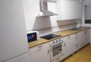 a kitchen with white cabinets and a sink and a microwave at Piso.2hab+2baños+garaje+Asc+A C. in Talavera de la Reina