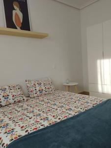a bedroom with a bed with colorful pillows on it at Piso.2hab+2baños+garaje+Asc+A C. in Talavera de la Reina
