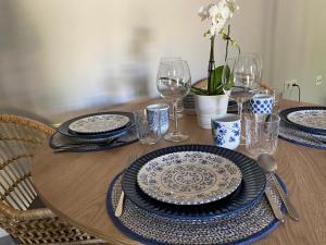 a wooden table with blue and white plates and wine glasses at Detached holiday house, 2 bedrooms, private garden, pool in Alhaurín de la Torre