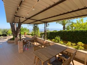 een patio met tafels en stoelen onder een luifel bij Detached holiday house, 2 bedrooms, private garden, pool in Alhaurín de la Torre