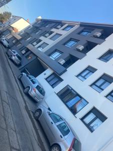 dois carros estacionados em frente a um edifício em SpaNish apartman em Niš