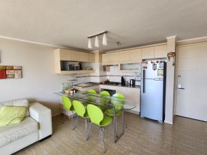 a kitchen with a table and chairs and a refrigerator at Departamento Laguna Vista Marina in Algarrobo