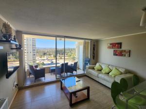 a living room with a couch and a large window at Departamento Laguna Vista Marina in Algarrobo