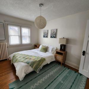 um quarto com uma cama e uma luz pendente em The Pandora Century Home em Kitchener