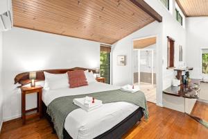 Un dormitorio con una cama grande y un techo de madera. en Hunchy Hideaway, en Montville