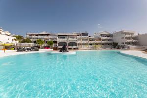 una gran piscina frente a algunos apartamentos en The Colors House, 629 - Private Apartment en Costa Teguise