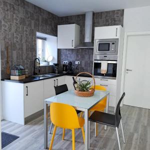 una cocina con mesa y sillas amarillas. en Casa Pyrrhula Murina - Private Jacuzzi, en Nordeste