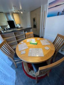 a dining room table with chairs and a kitchen at Holiday Home In Cardiff. Sleeps 6 in Cardiff