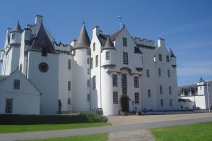 a large white building with a clock on it at Atholl Arms in Blair Atholl