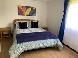 a bedroom with a bed with a purple comforter at Hotel Cerro Fuerte in Sopó