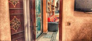 Riad Arabic House & Spa في مراكش: مرآة في غرفة مع أريكة وتلفزيون
