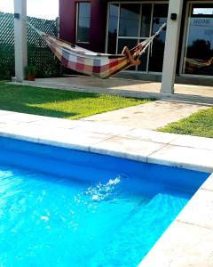 a hammock is hanging over a pool of water at AMOR & MIEL in General Alvear