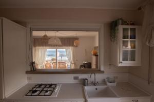 cocina con ventana y vistas al océano en TERRACINA SEA FRONT FANTASTIC APARTMENT WITH ONE CAR PRIVATE OPEN PARKING en Terracina