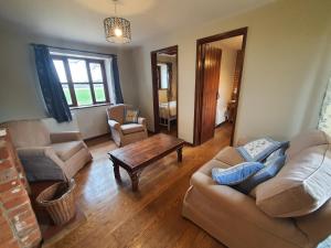 a living room with two couches and a coffee table at Cosy Barn Conversion 3BR (4 pax), Quiet, Close to Pin Mill 