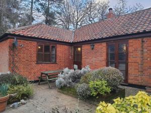 a brick house with a bench in a garden at Cosy Barn Conversion 3BR (4 pax), Quiet, Close to Pin Mill 