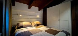 a bedroom with a bed with a large white headboard at Aufidena Apartment in Alfedena